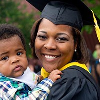woman graduate holding her child
