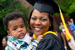woman graduate holding her child