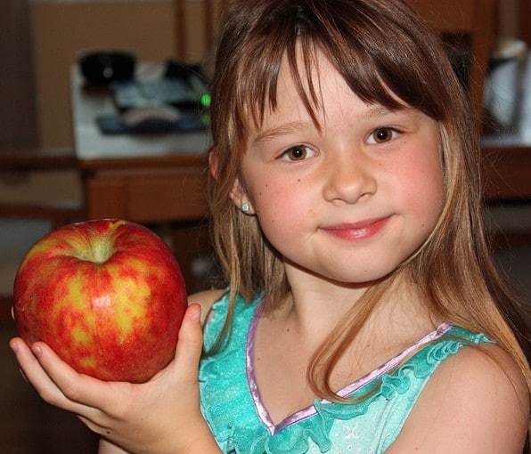 girl holding apple