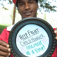 John from Homewood holds paper plate saying "Help fight child hunger one meal at a time!"