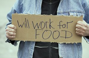 Man holding sign that says "Will work for food"