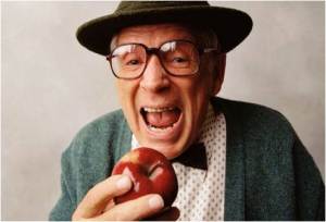 elderly man biting apple