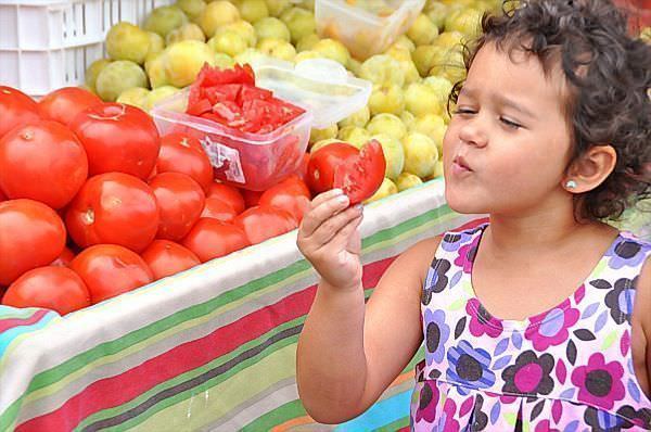 girl tasting tomato via richandkathy.com