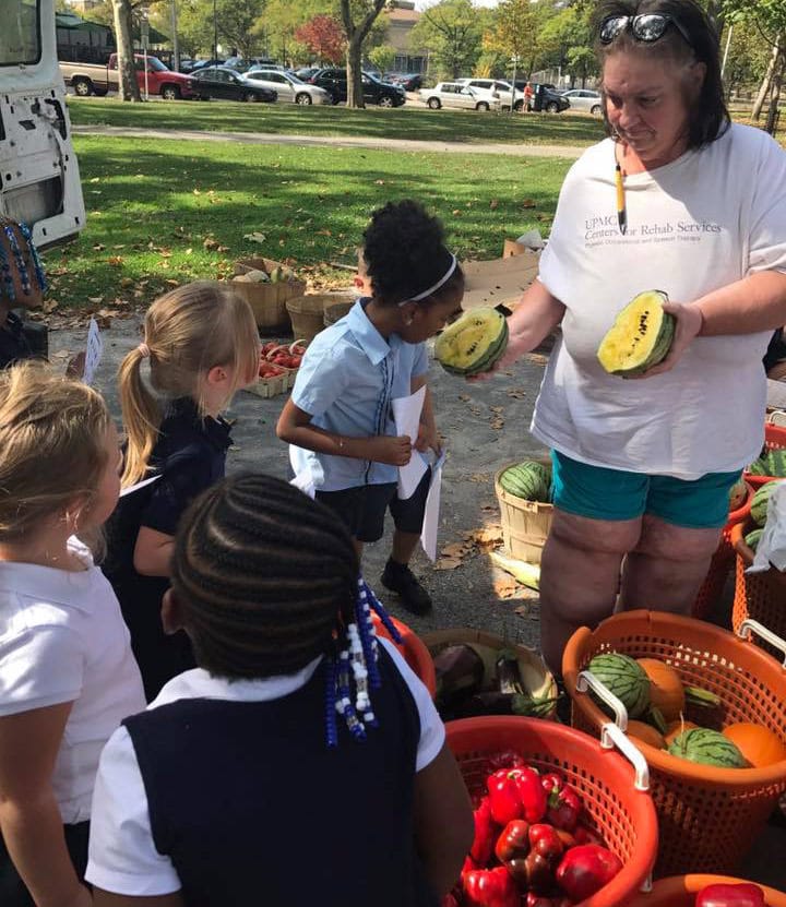 Allegheny Traditional Academy girls investigate melon at the North Side farmers market, Oct. 2017