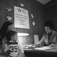 A mother signs up to receive food supplements utilizing the U.S. Department of Agriculture's Women, Infant, and Children’s (WIC) food nutrition program in Pineville, Kentucky in January 1974. Photo courtesy of National Archives and Records Administration.
