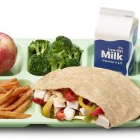 Photo of schoo lunch tray with red apple, broccoli, container of milk, whole wheat tortilla sandwich with chicken and bell peppers, and sweet potato french fries (via USDA/flickr)